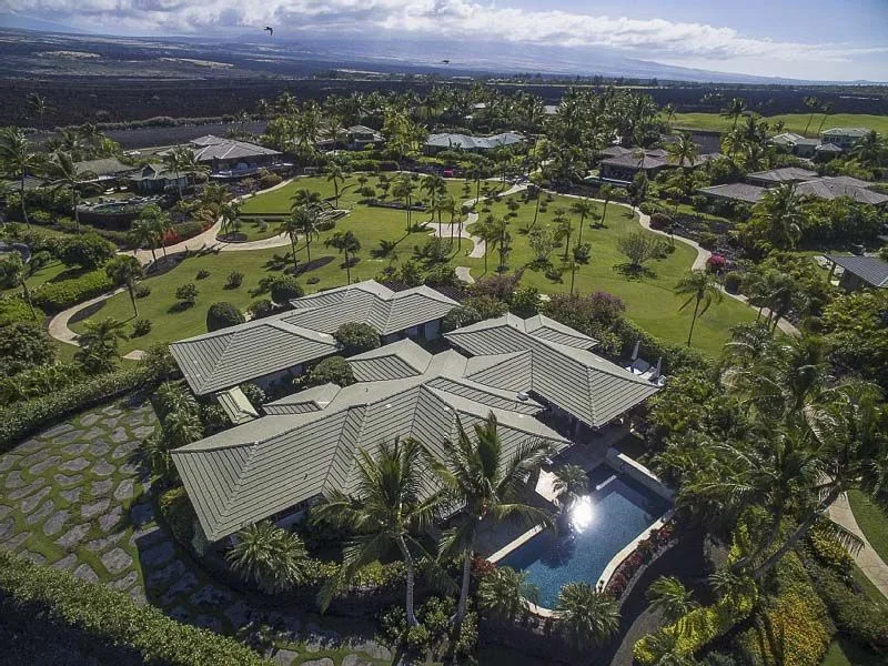 An aerial view of landscaped grounds with buildings and a swimming pool.