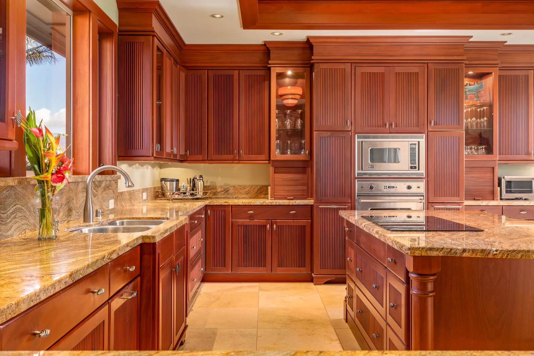 A wood-paneled kitchen with stone countertops and built-in appliances.