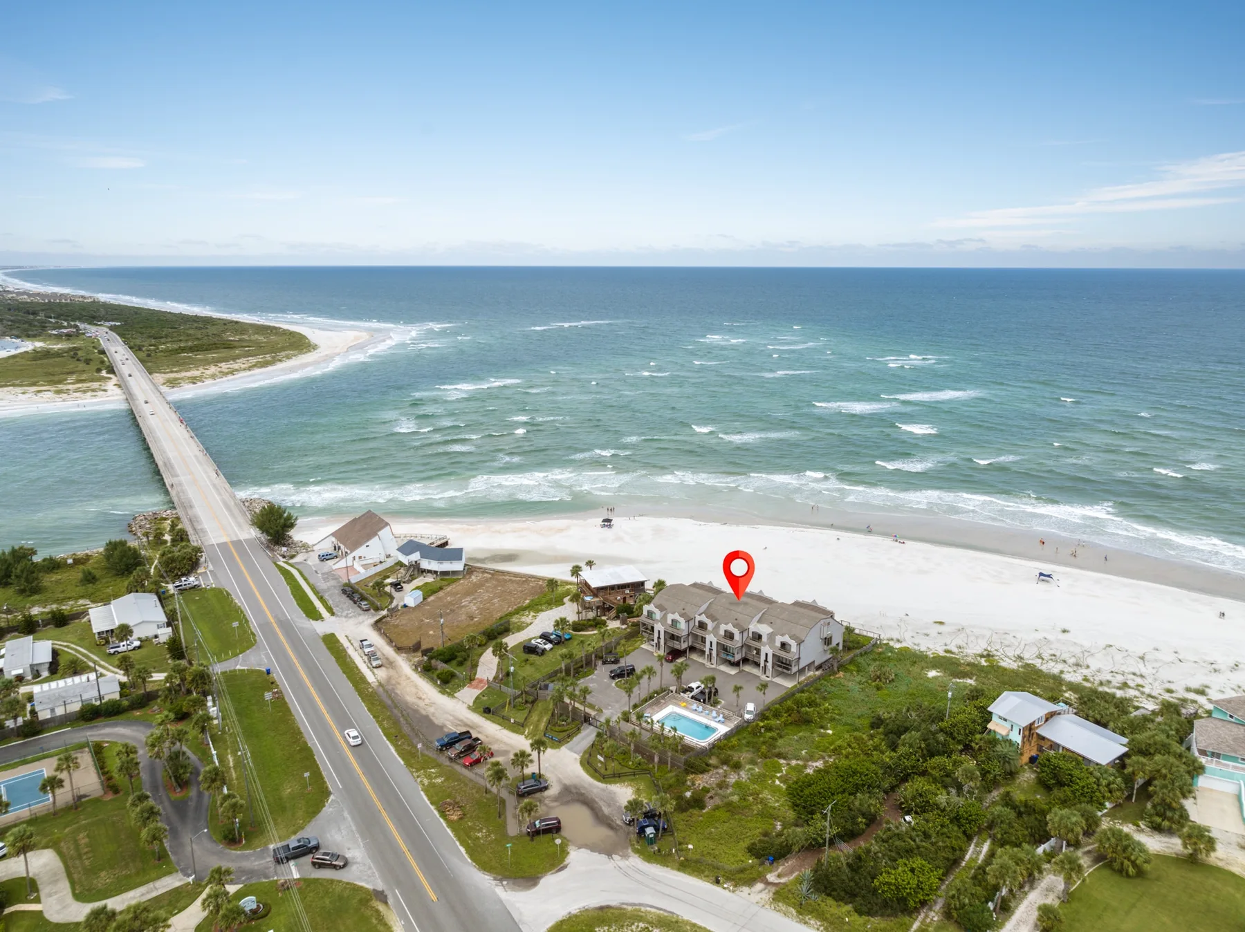 Aerial view of a beachfront property beside a road and ocean.