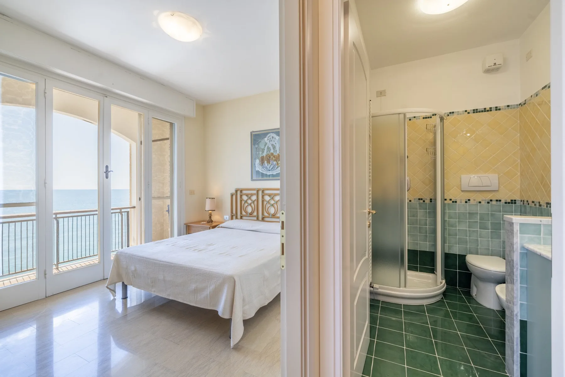 Un dormitorio con una cama junto a ventanales que dan a un balcón.