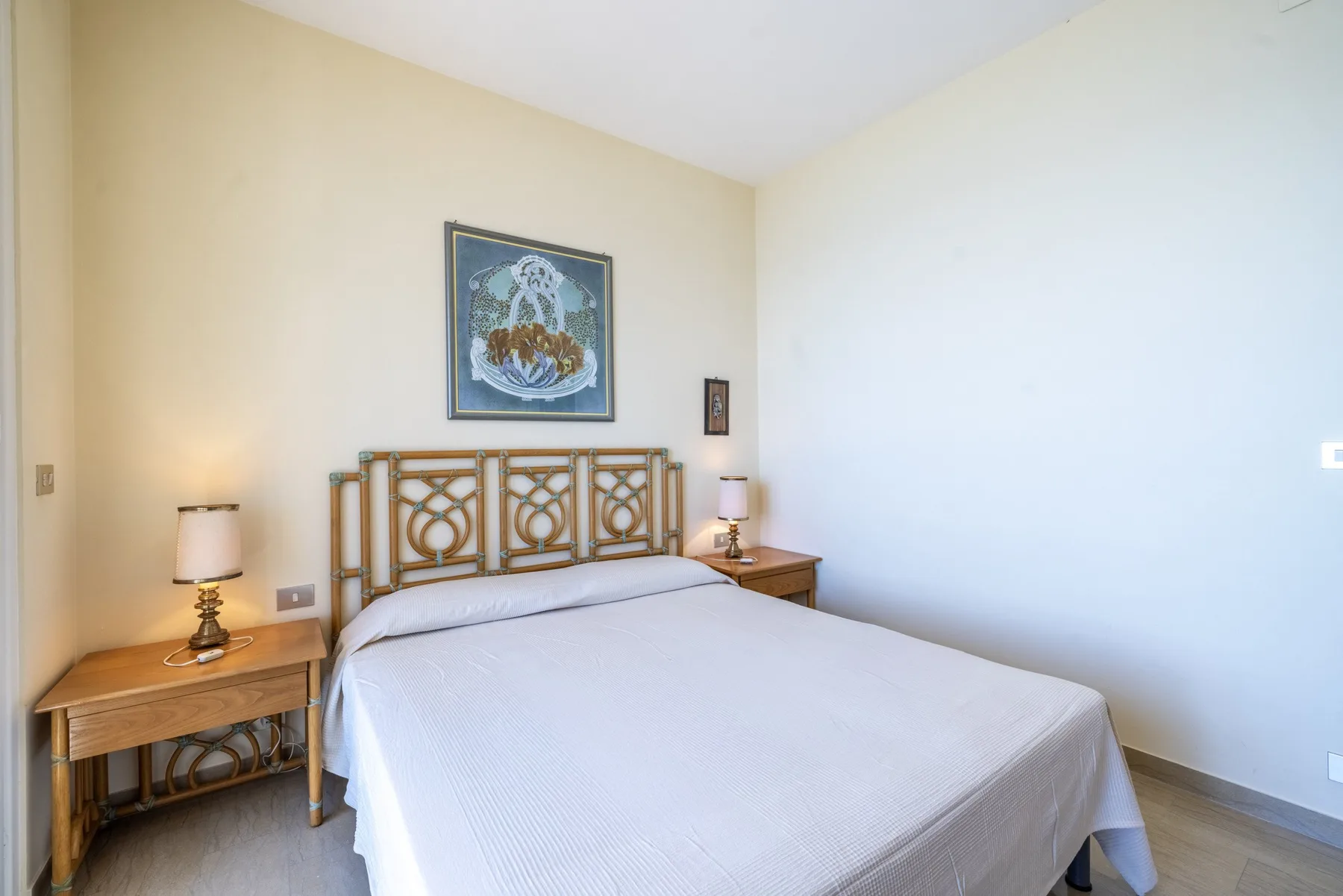 Un dormitorio con una cama doble, cabecero de madera y mesillas de noche.