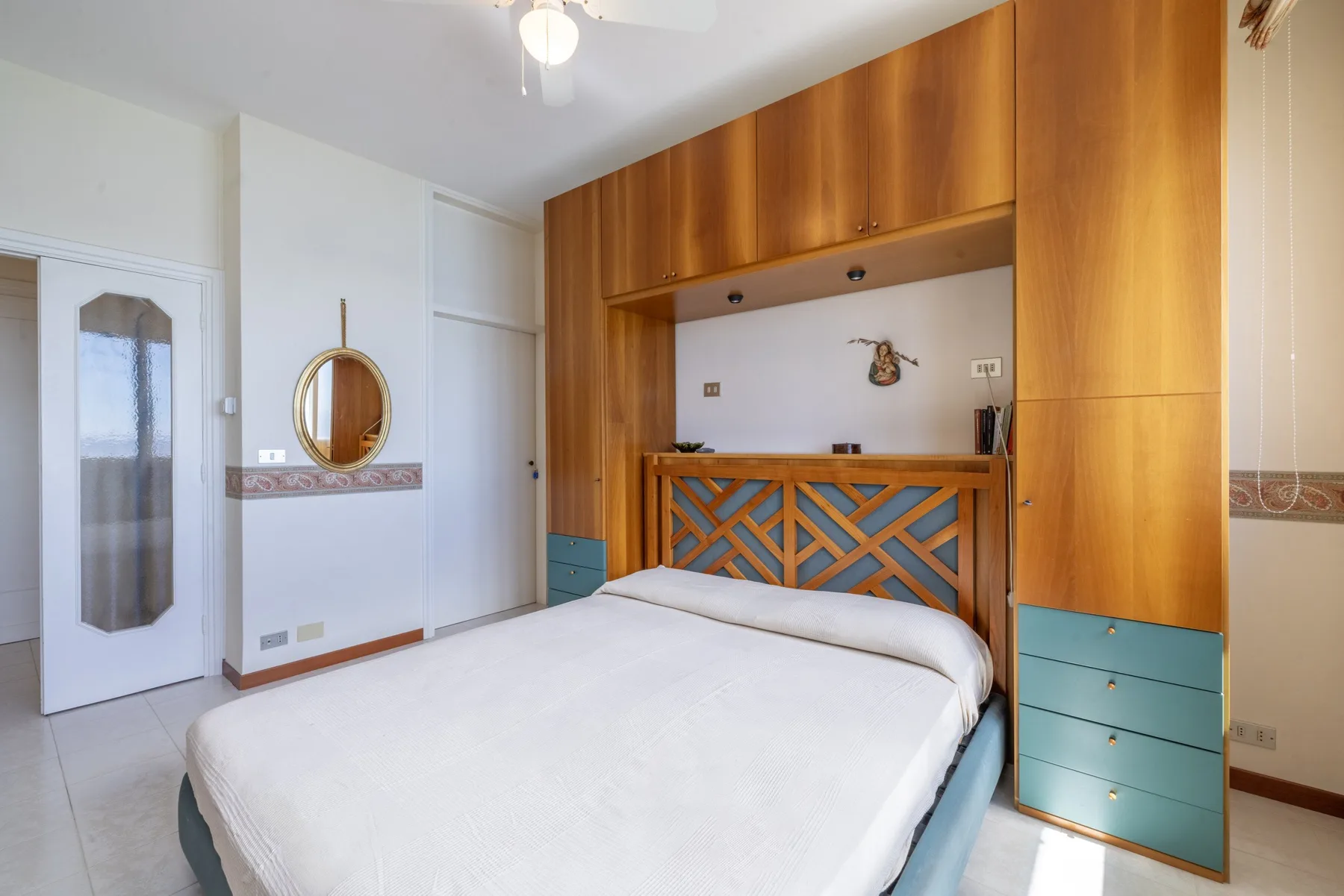 Un dormitorio con una cama y armarios empotrados de madera junto a la pared.