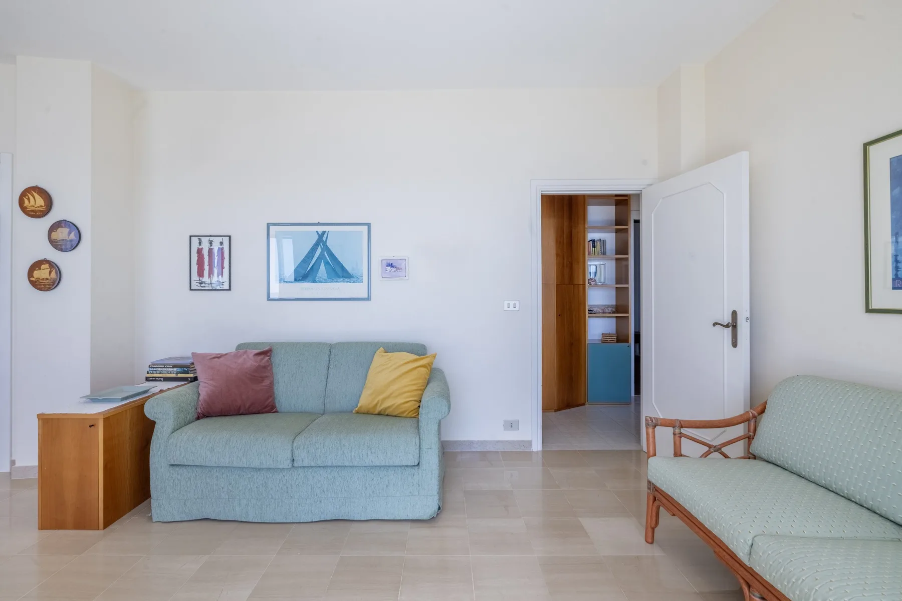 Una sala luminosa con asientos azul claro y una puerta abierta.