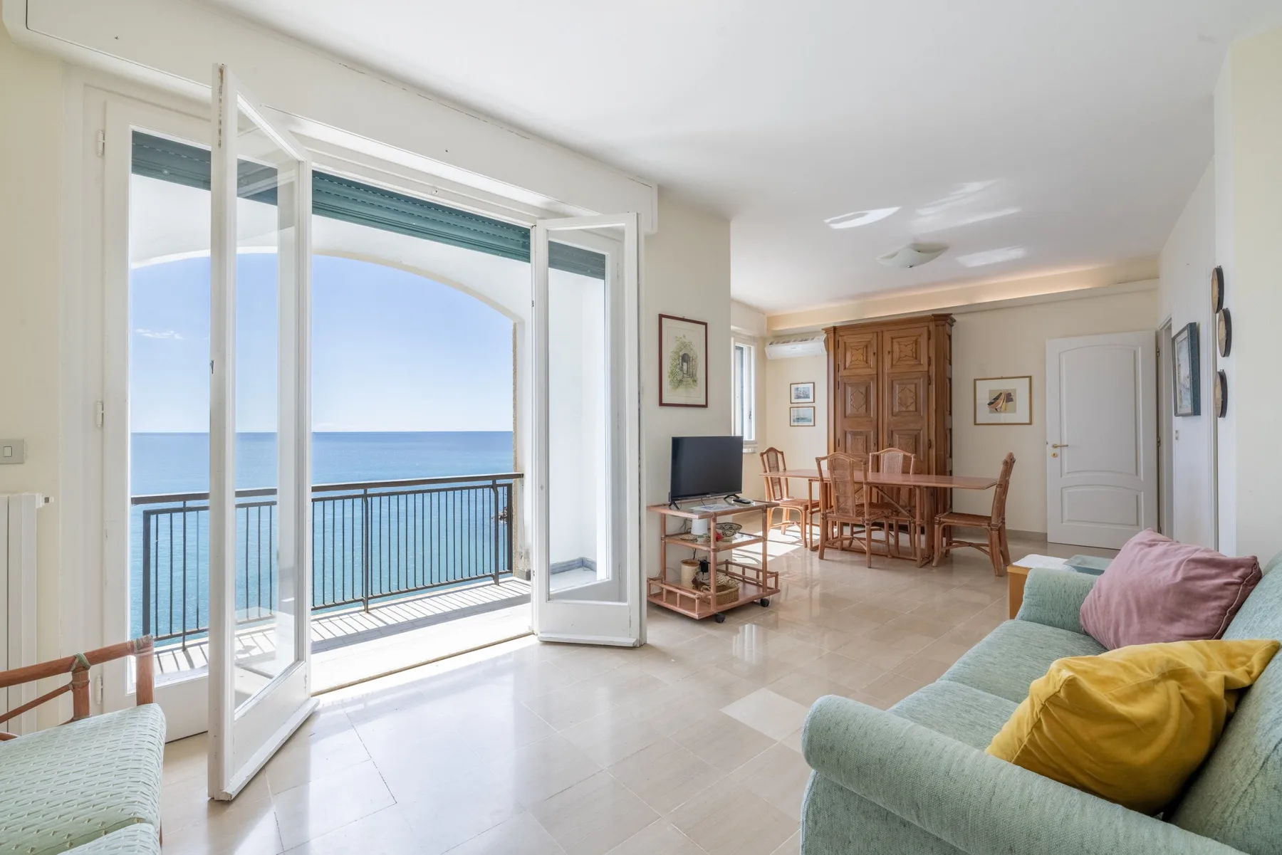 Una luminosa sala de estar y comedor da a un balcón con vistas al mar.