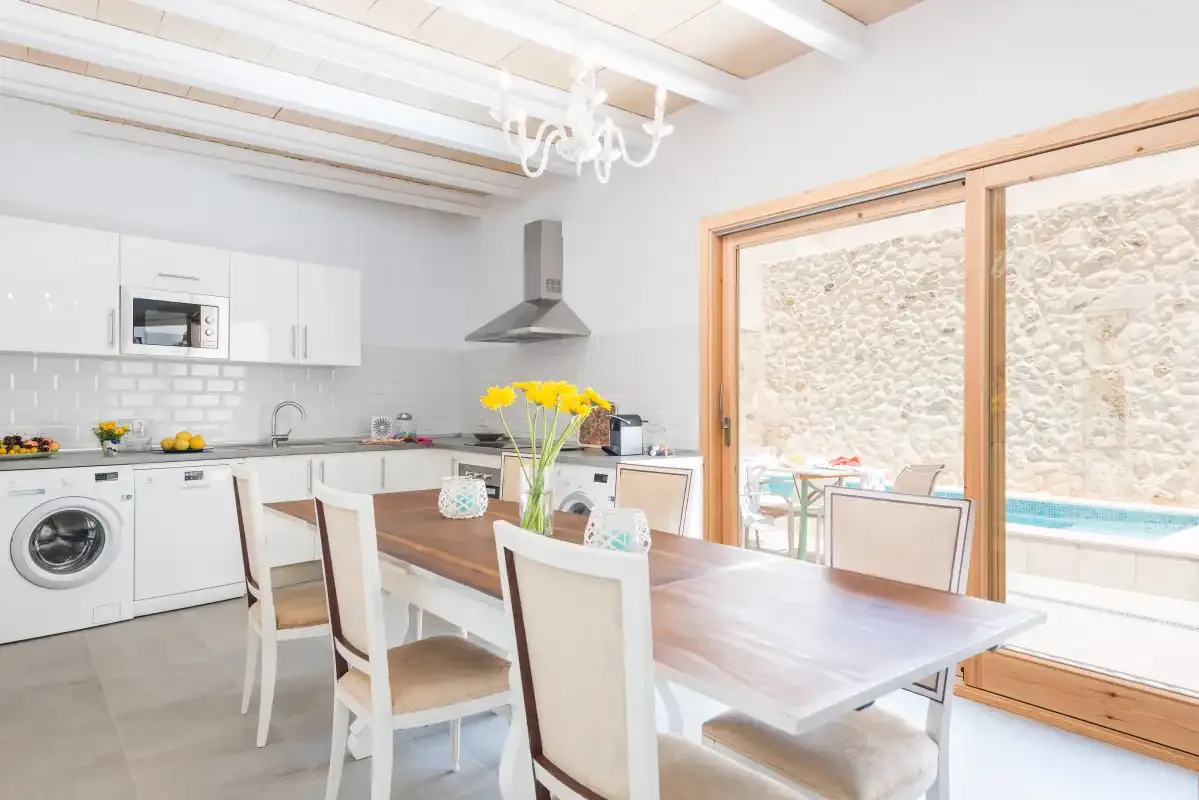 A bright kitchen and dining area opens onto a patio with a swimming pool.