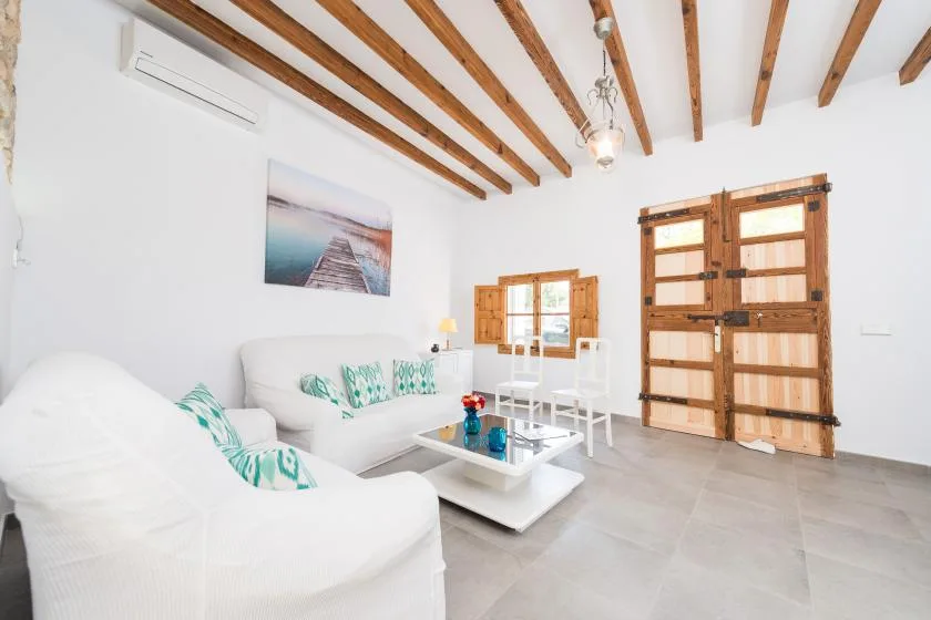A bright living room with white seating and a low coffee table.