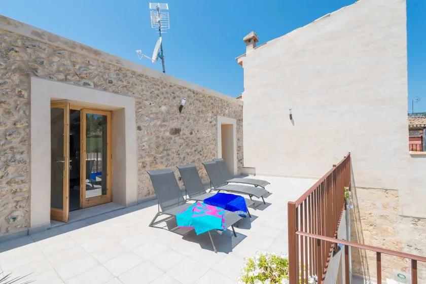 A rooftop terrace with outdoor seating and a small table.