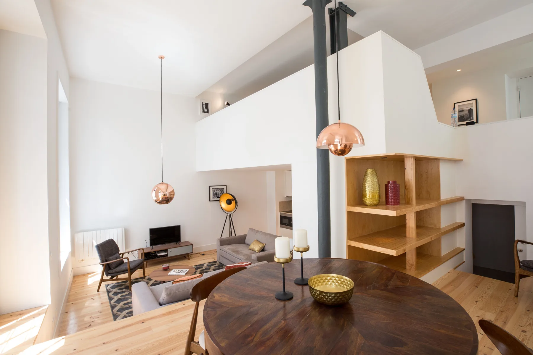 Sala de estar y comedor de planta abierta con asientos y una mesa redonda.