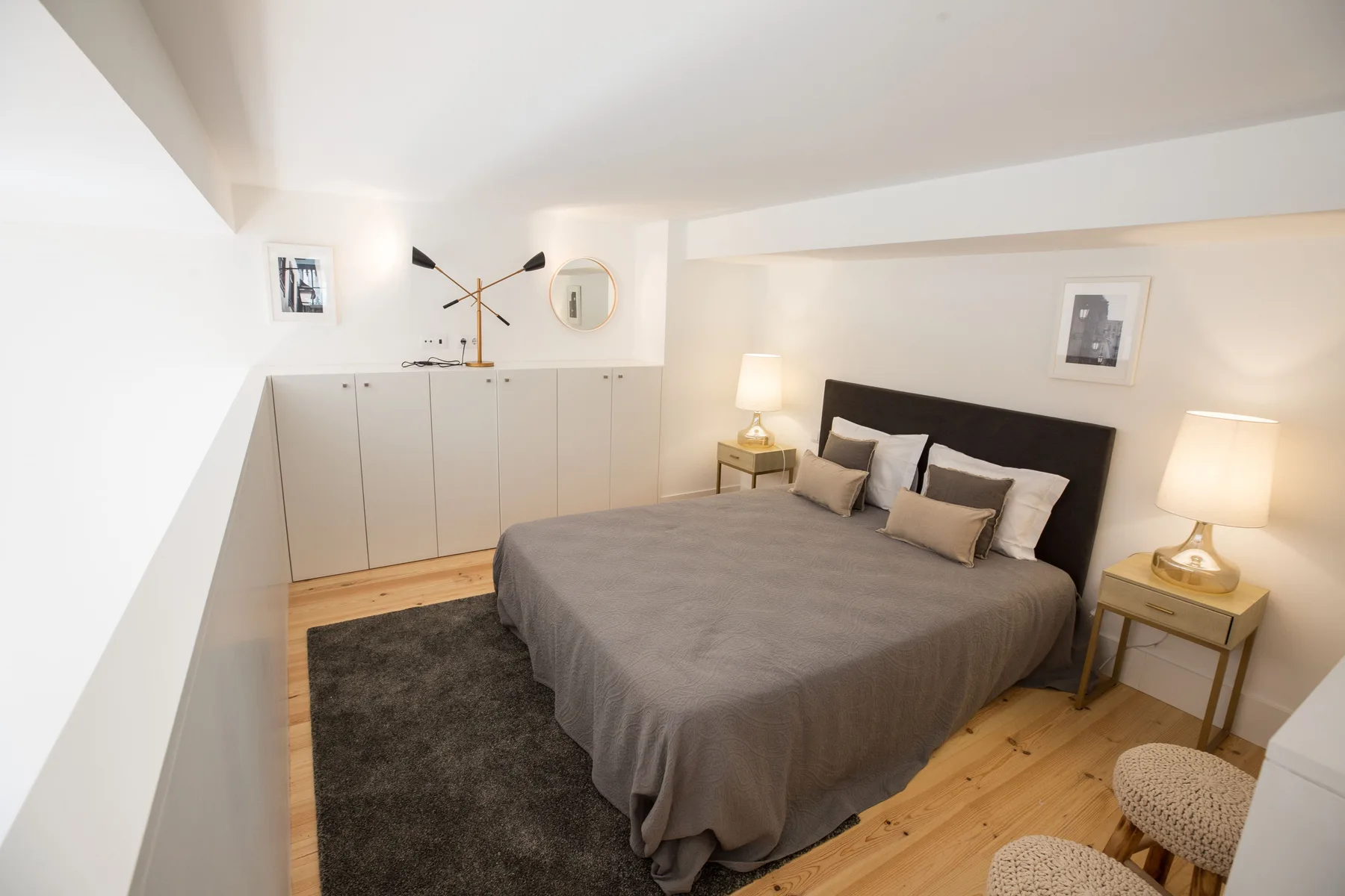 Un dormitorio luminoso con una cama doble, mesitas de noche y un armario.