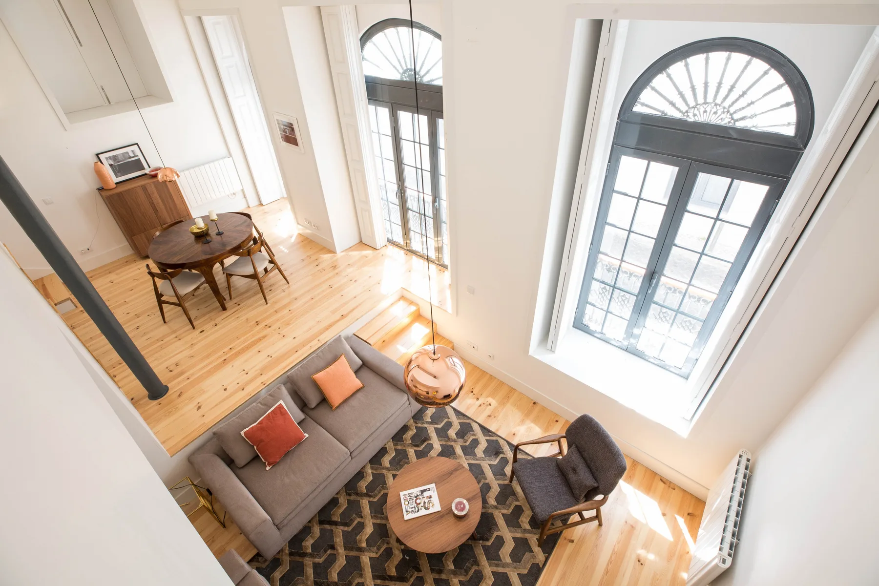 Una sala luminosa con asientos junto a altas ventanas arqueadas.