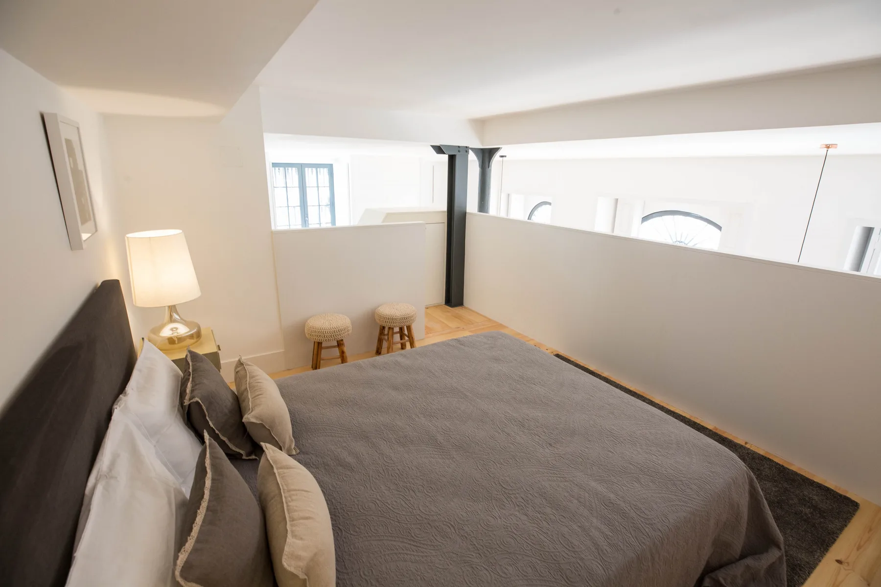 Un dormitorio con una cama tendida y una lámpara al lado.