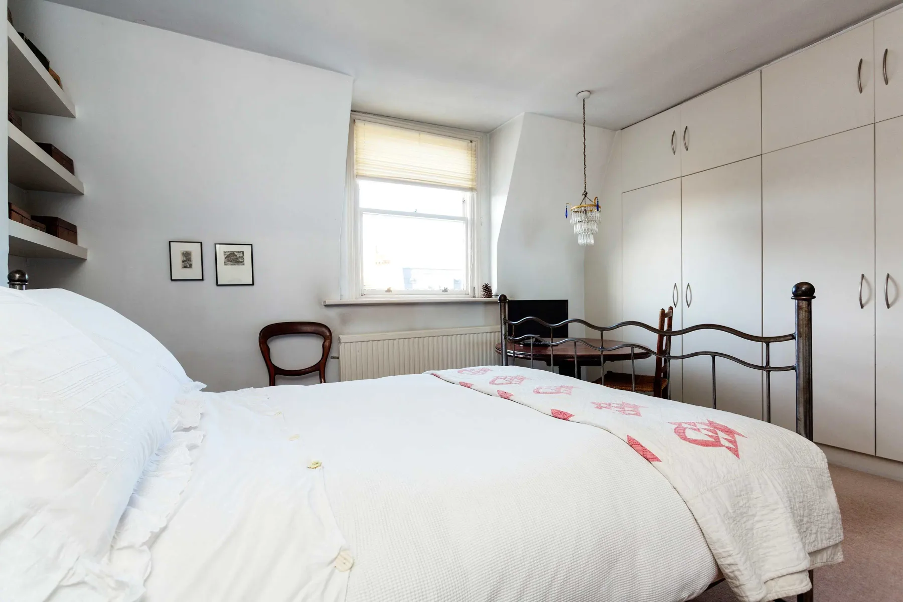 Un dormitorio con una cama, armarios y una ventana.