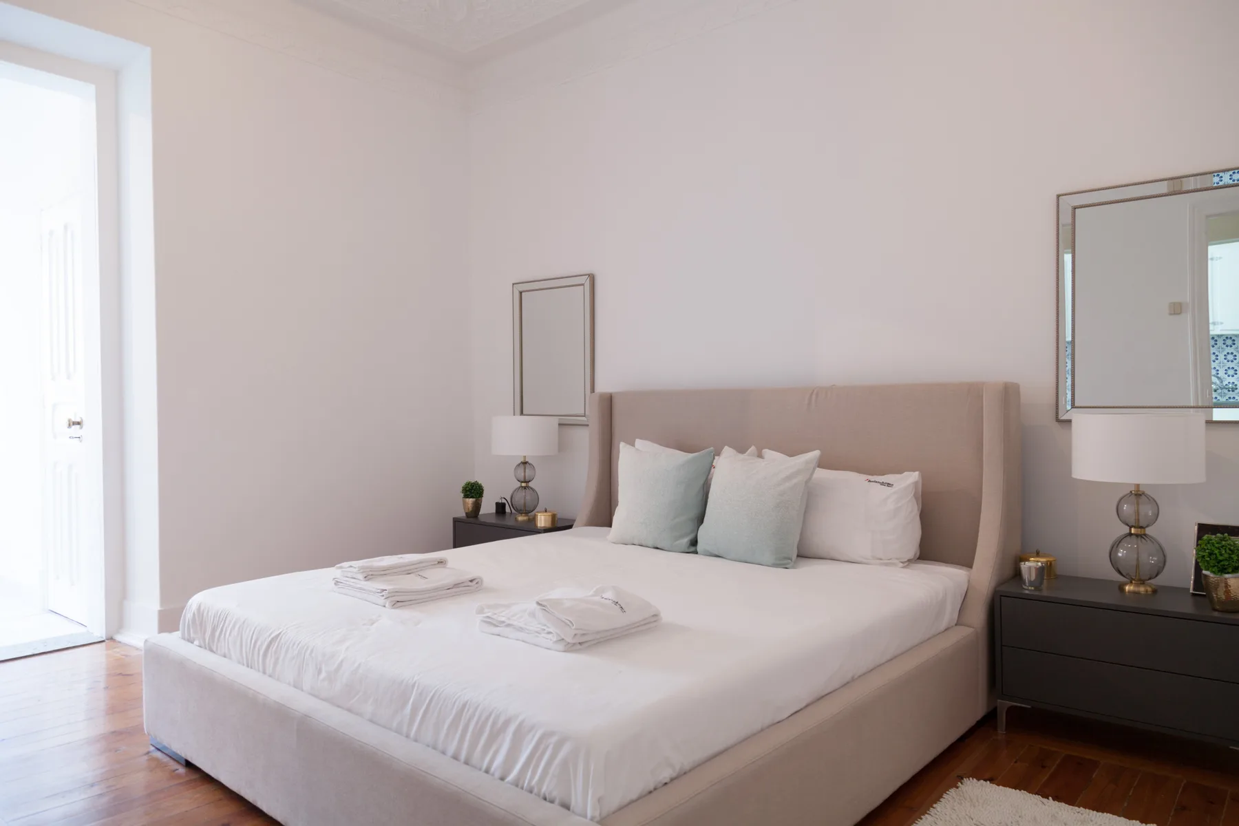 Un dormitorio con una cama hecha y toallas dobladas.