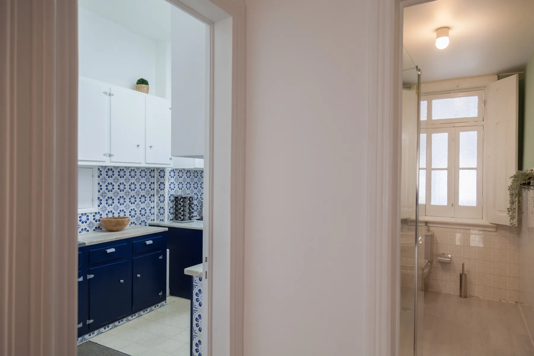Un pasillo da a una cocina y un baño.