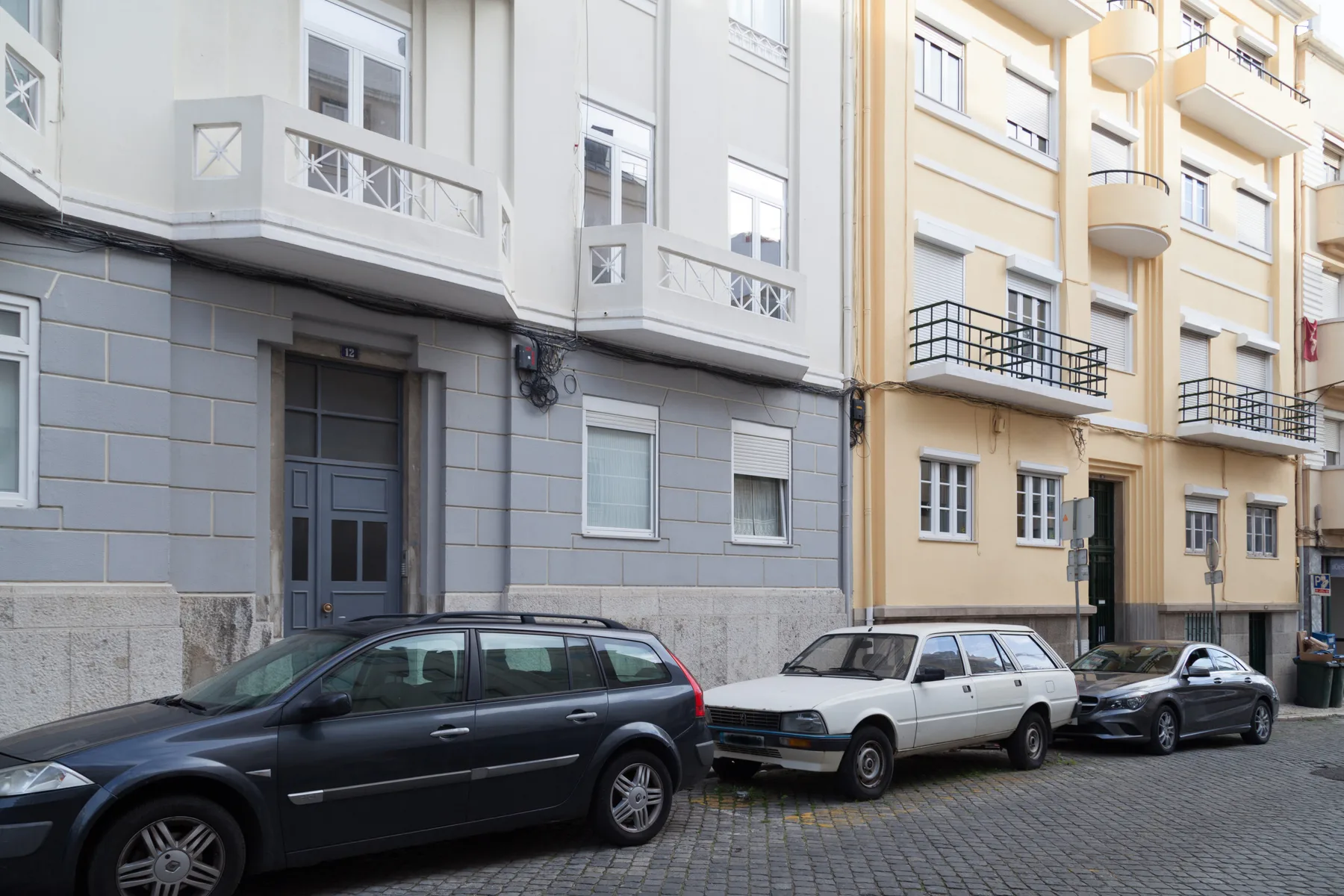 Vista de una calle con edificios de apartamentos y coches aparcados junto al bordillo.