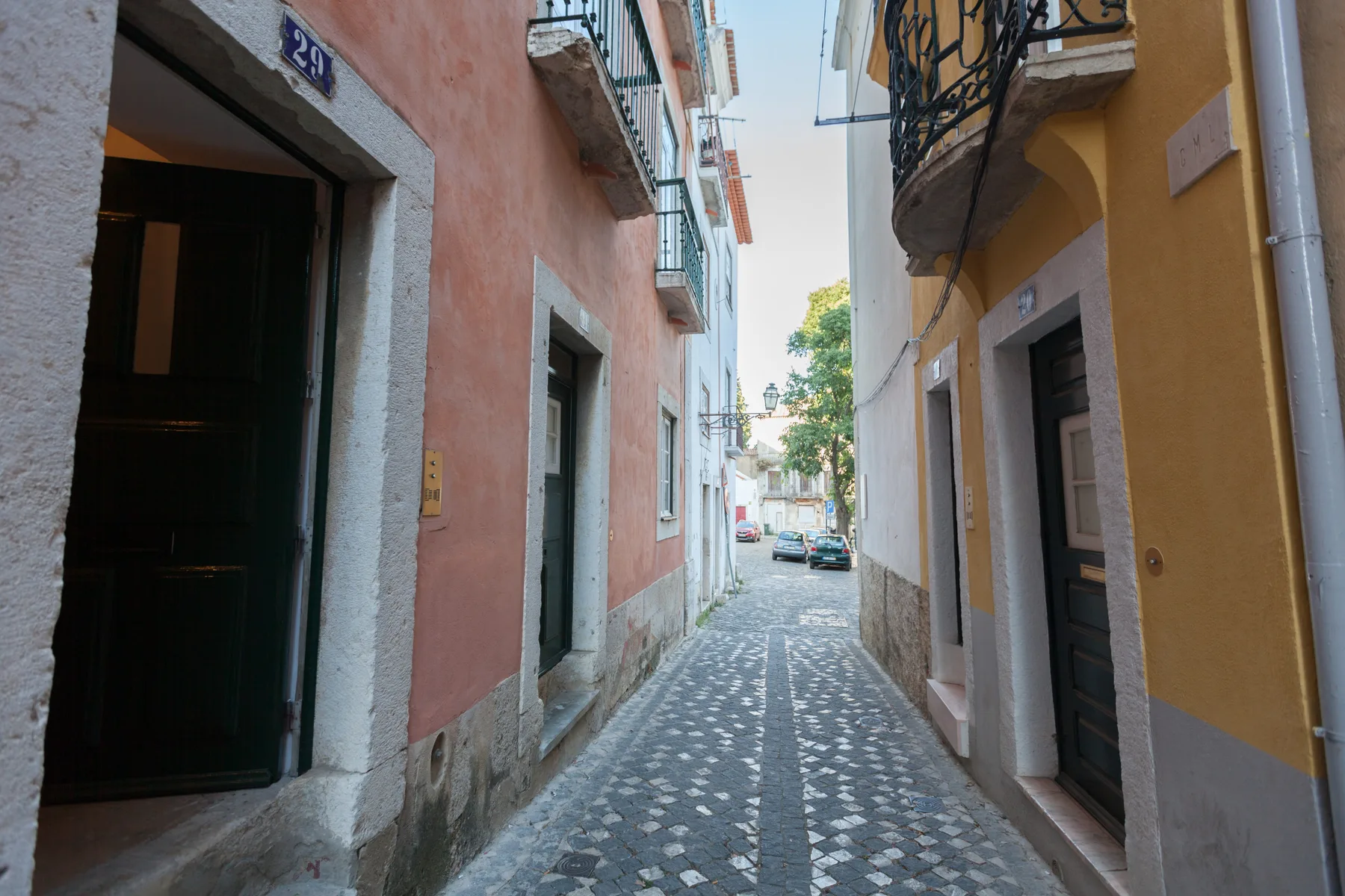 Una calle estrecha de adoquines pasa entre edificios de colores.