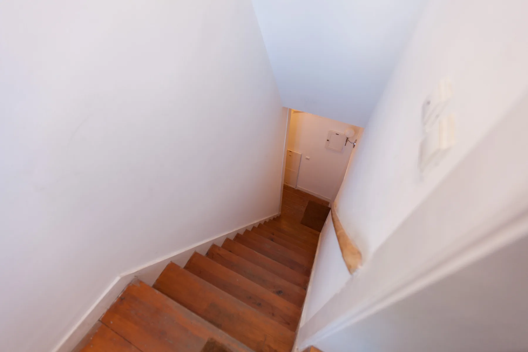 Una escalera interior estrecha desciende hasta un pequeño rellano.