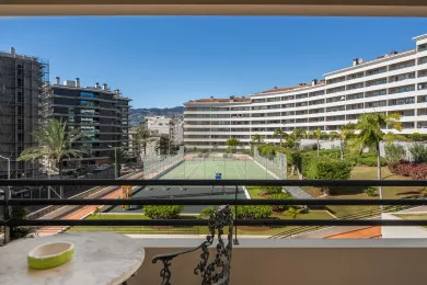 A balcony overlooks a landscaped courtyard and surrounding apartment buildings.