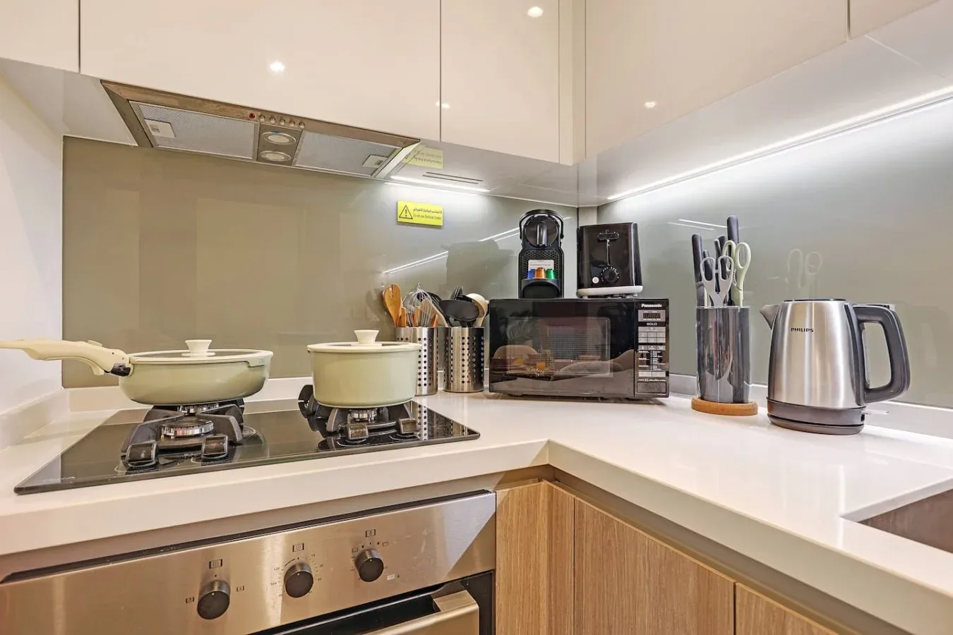Una cocina moderna con una estufa, utensilios de cocina y electrodomésticos sobre la encimera.