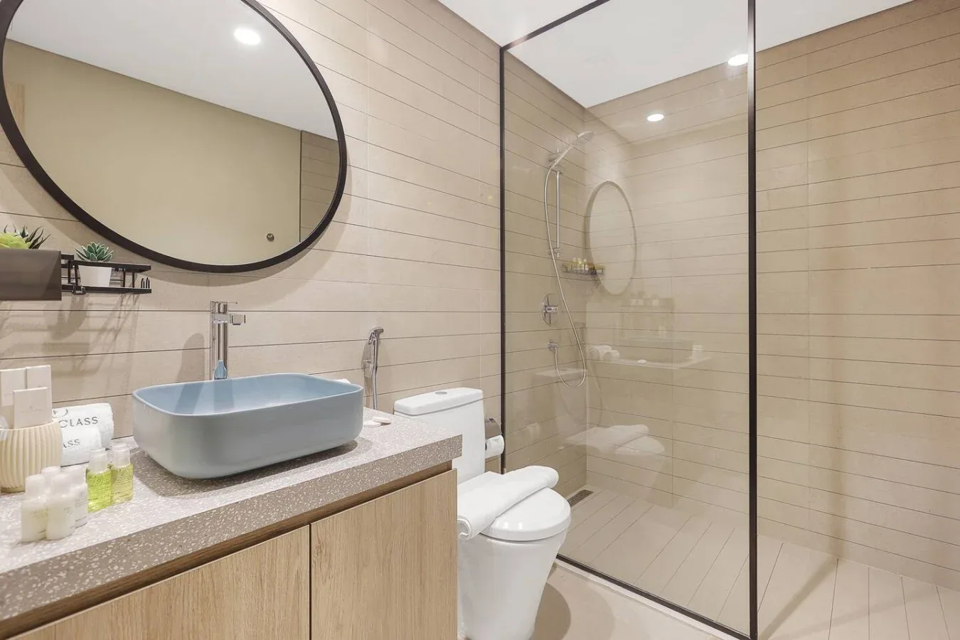 Un baño moderno con lavabo, inodoro y ducha con mampara de vidrio.