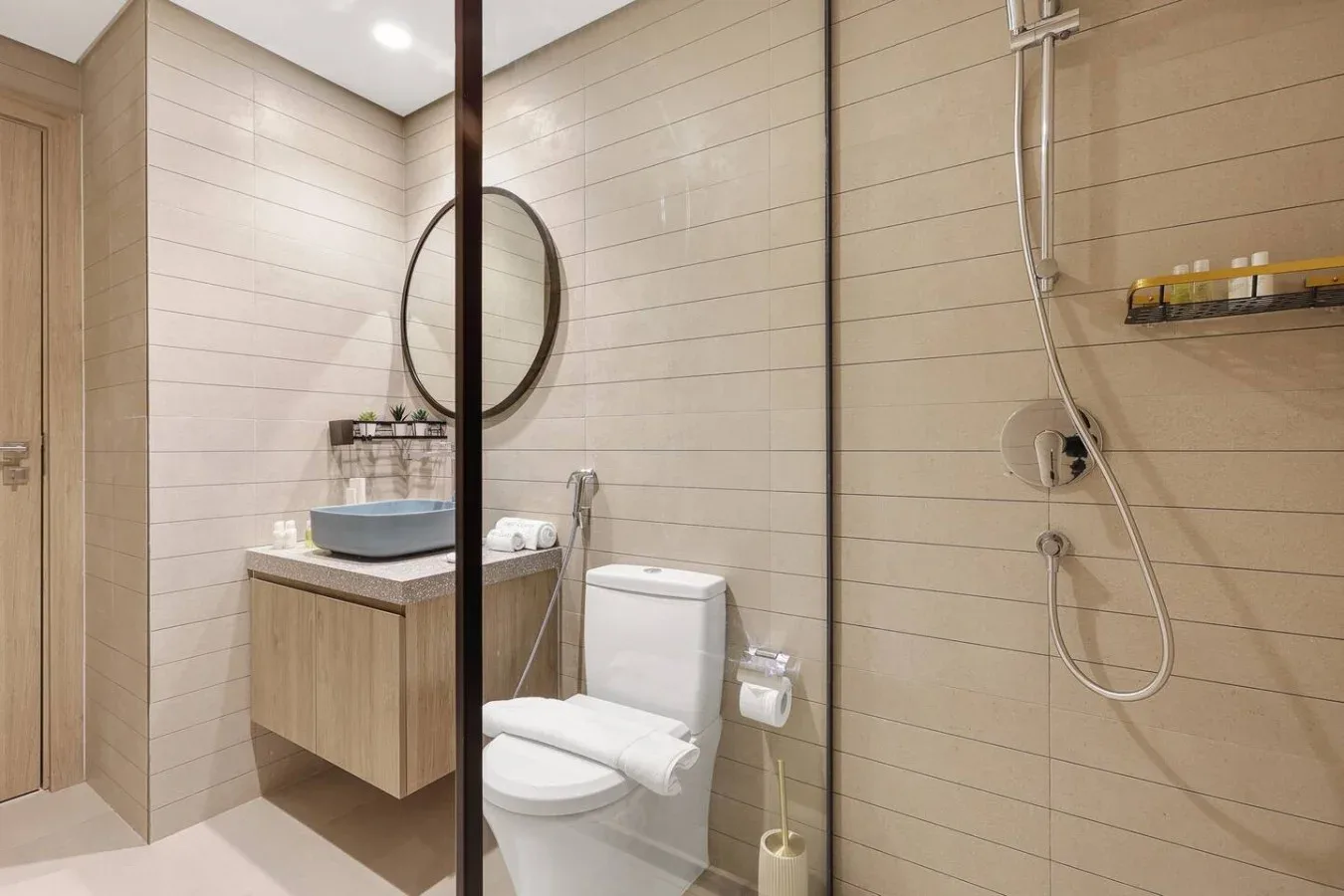 Un baño revestido de azulejos con lavabo, inodoro y ducha.