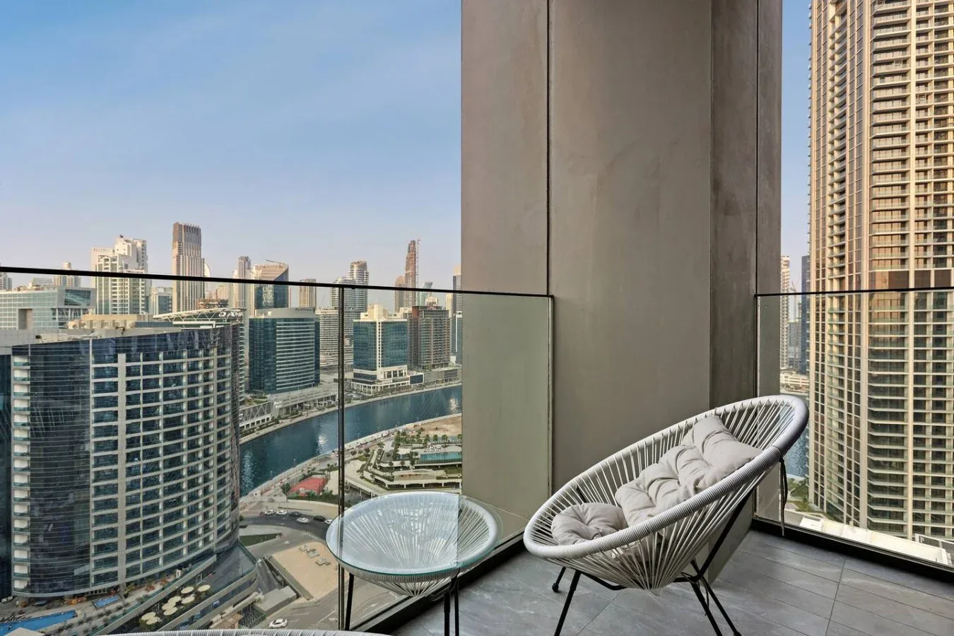 Una zona de estar en un balcón ofrece vistas de varios edificios altos.