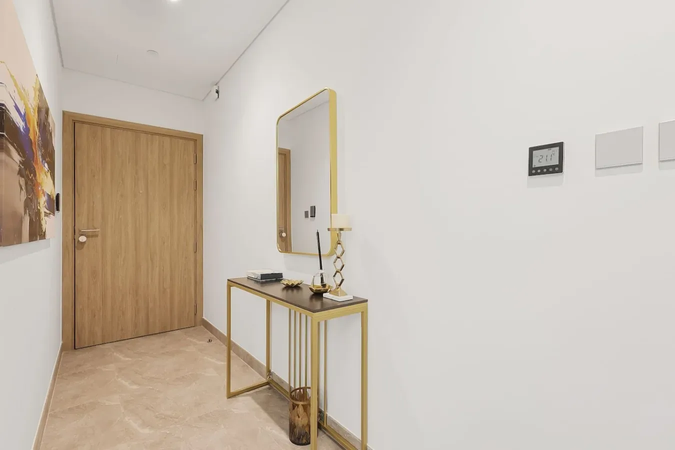 Un recibidor luminoso con una puerta de madera y una consola estrecha.