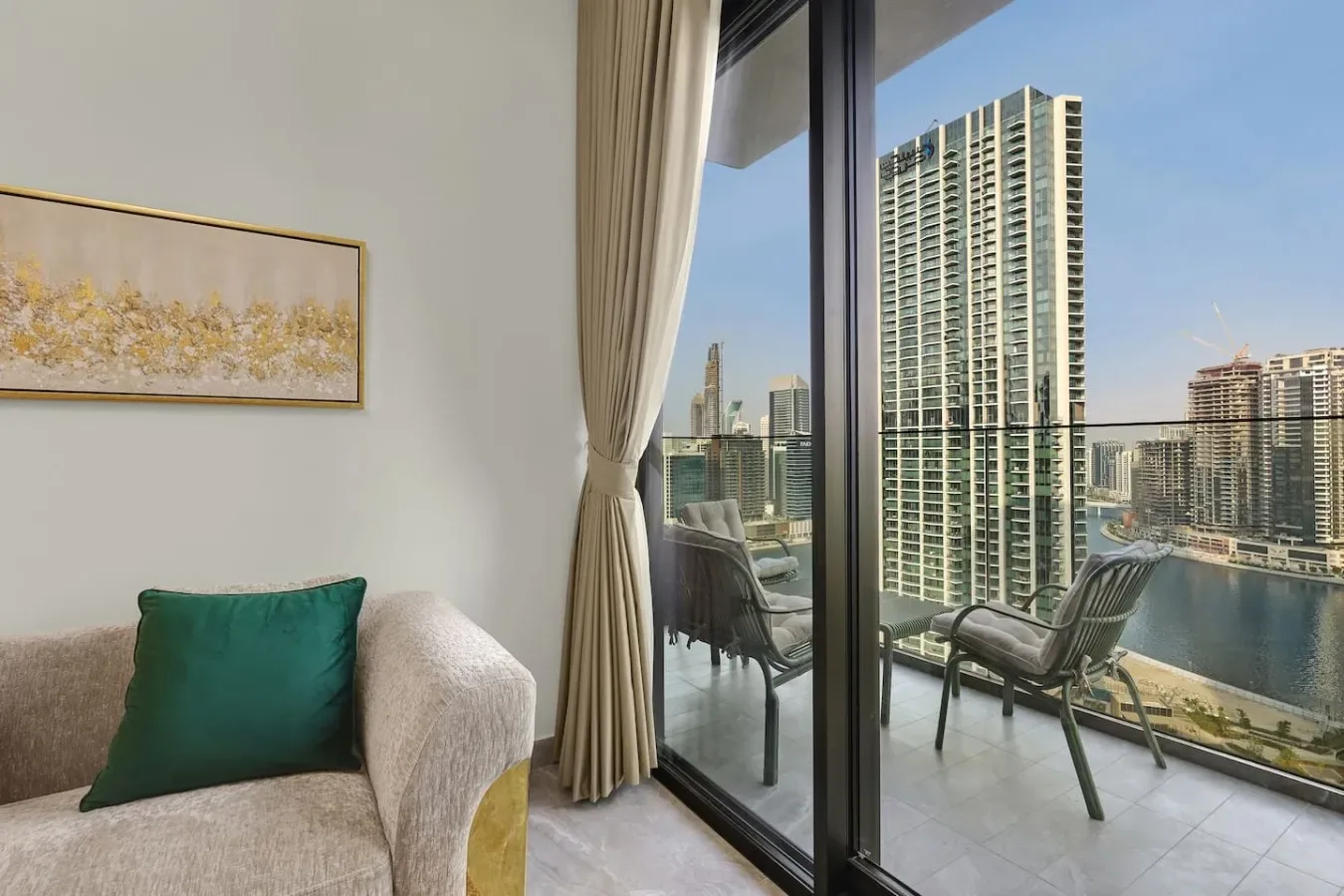 Una sala de estar da a un balcón con asientos y vistas de la ciudad.