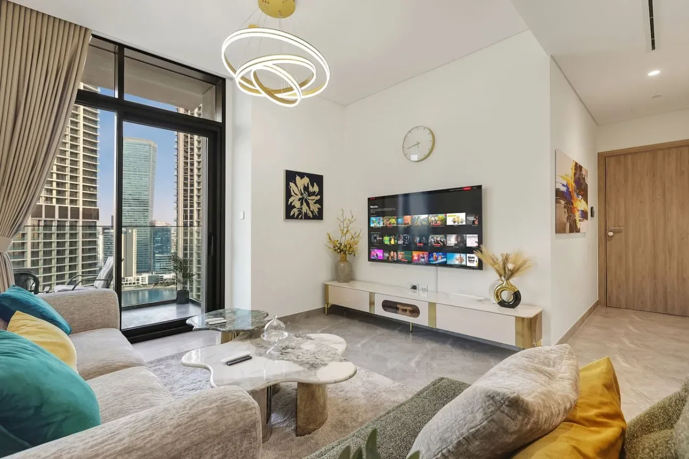 Una sala luminosa con asientos, un televisor y ventanas de piso a techo.