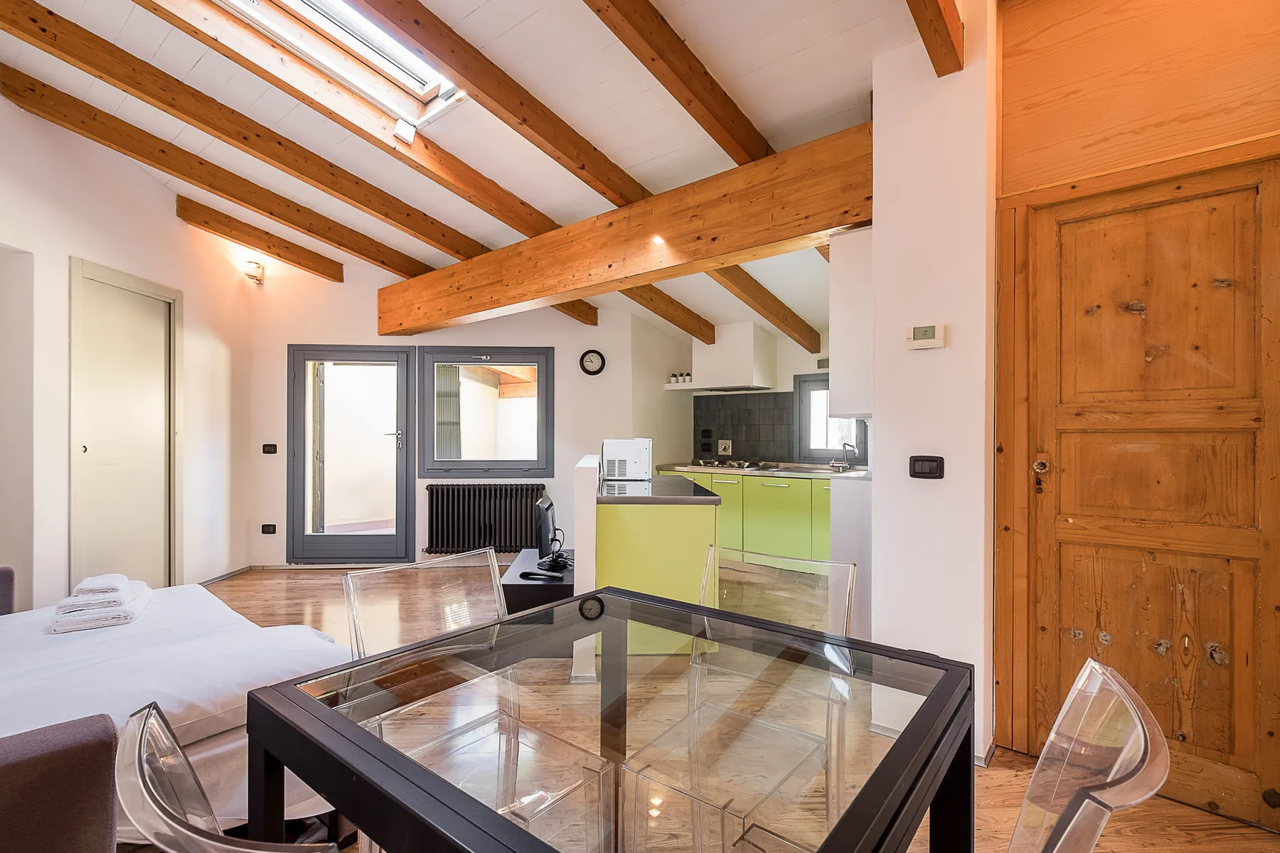 Una habitación diáfana y luminosa combina una zona para dormir, una mesa y una cocina compacta.