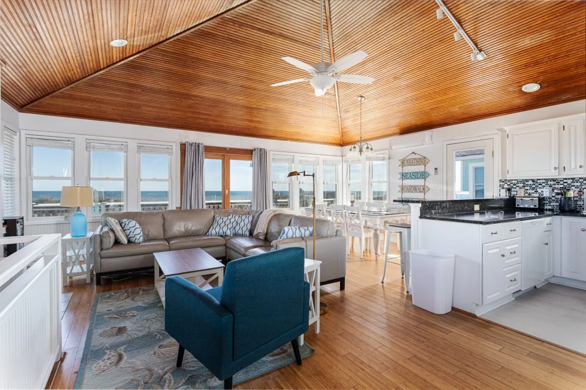 An open living and kitchen area with seating beside large windows.