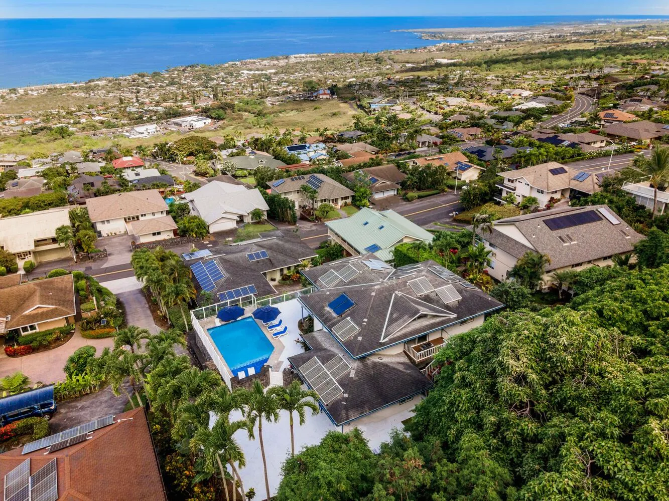 Vista aérea de un barrio costero con casas y una piscina.