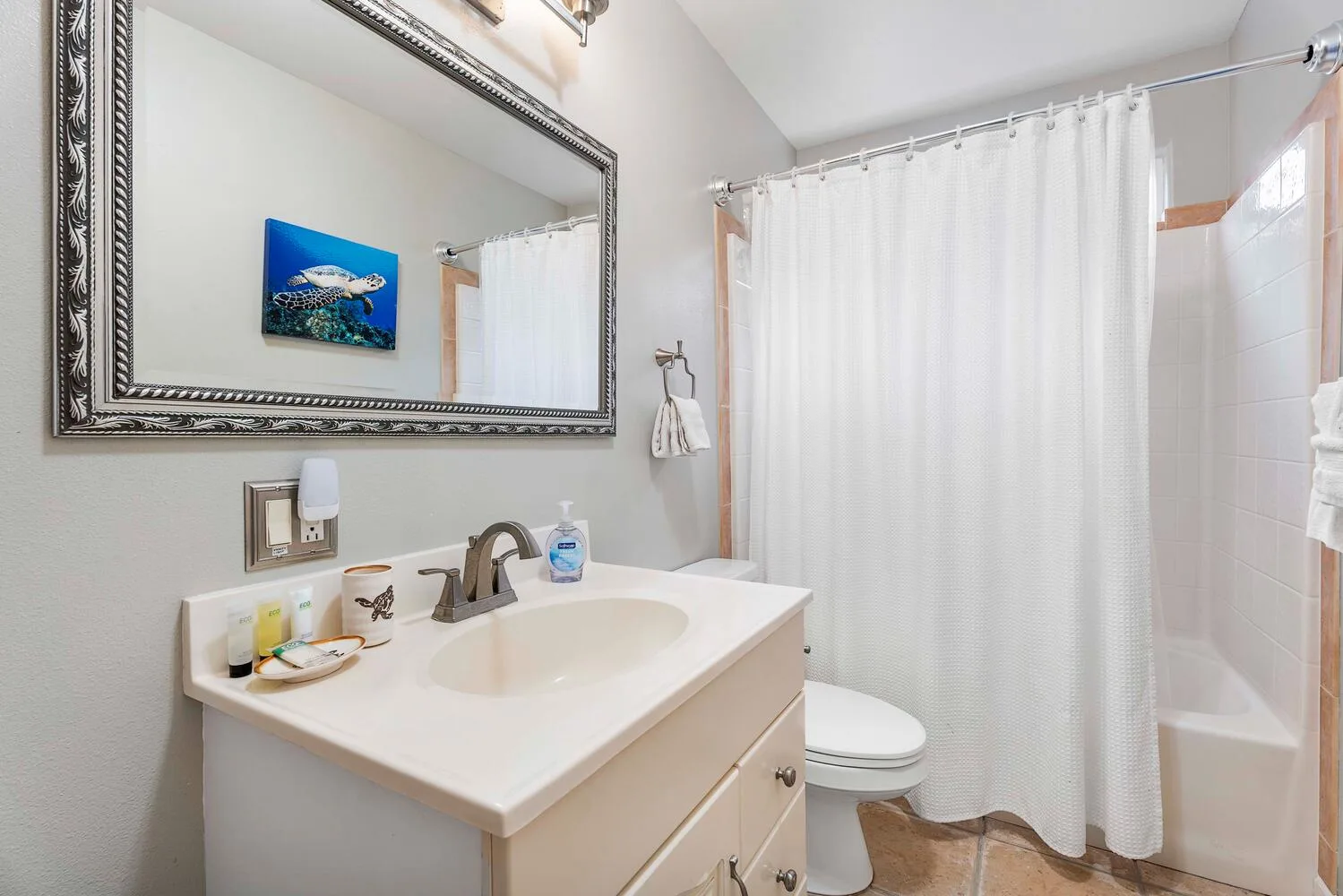 Un baño con lavabo, espejo y ducha con cortina.