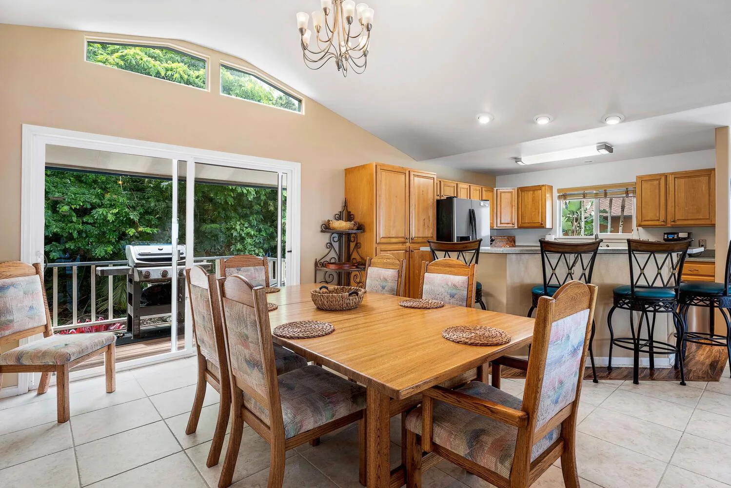 Comedor con una mesa de madera y una cocina abierta al fondo.