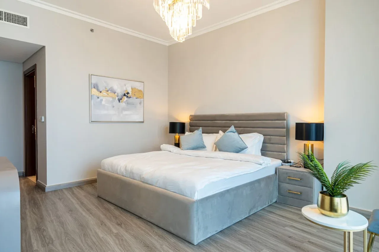 A bedroom with a large bed, bedside tables, and a framed wall picture.