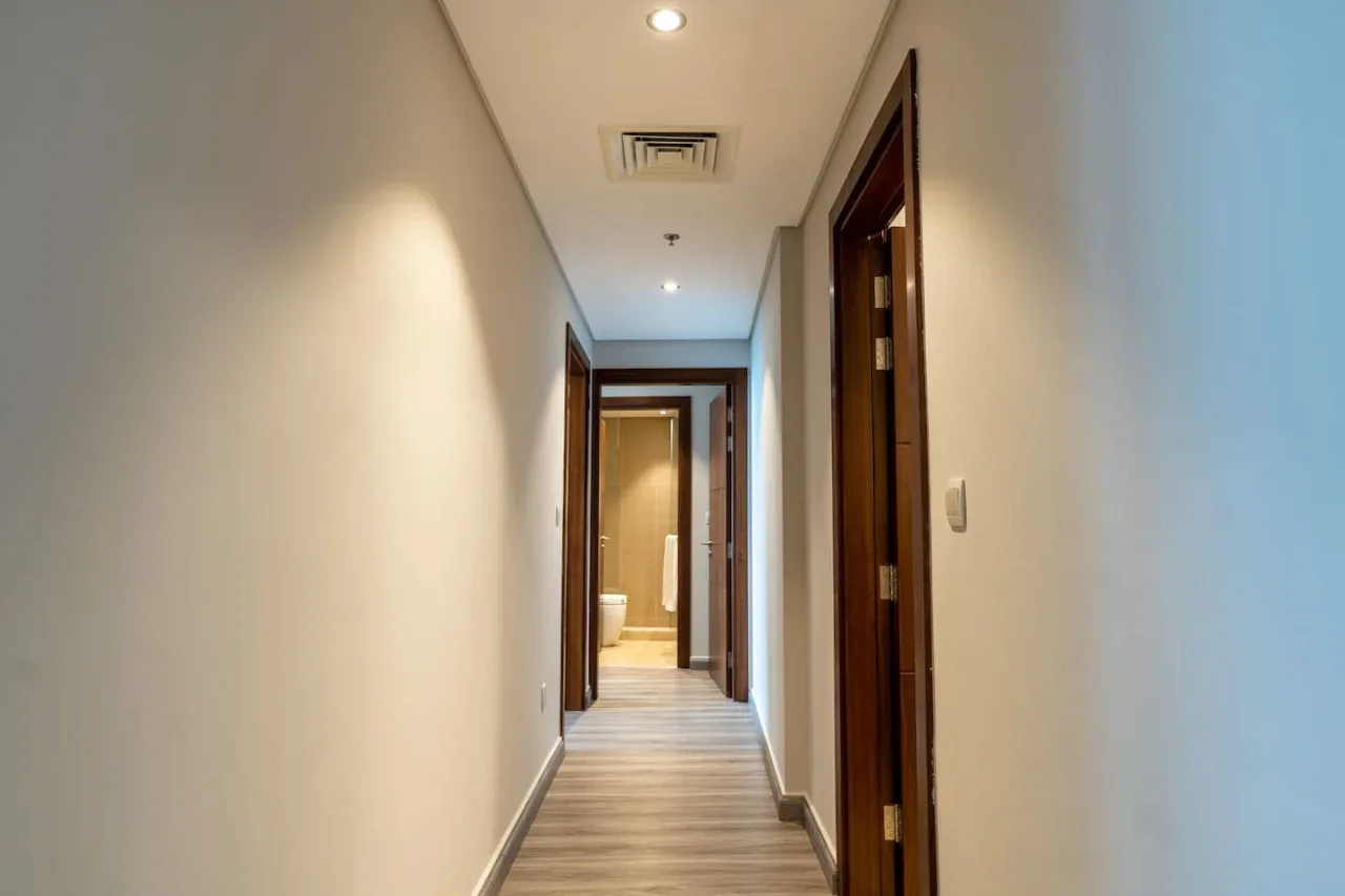 A hallway with light walls and wood-look flooring.
