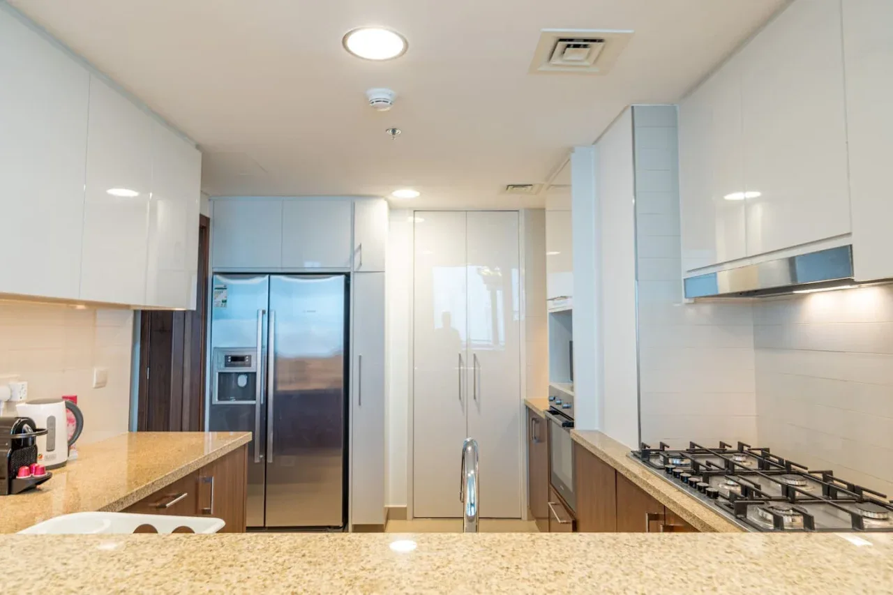 Kitchen with a refrigerator, cabinets, and a cooktop.
