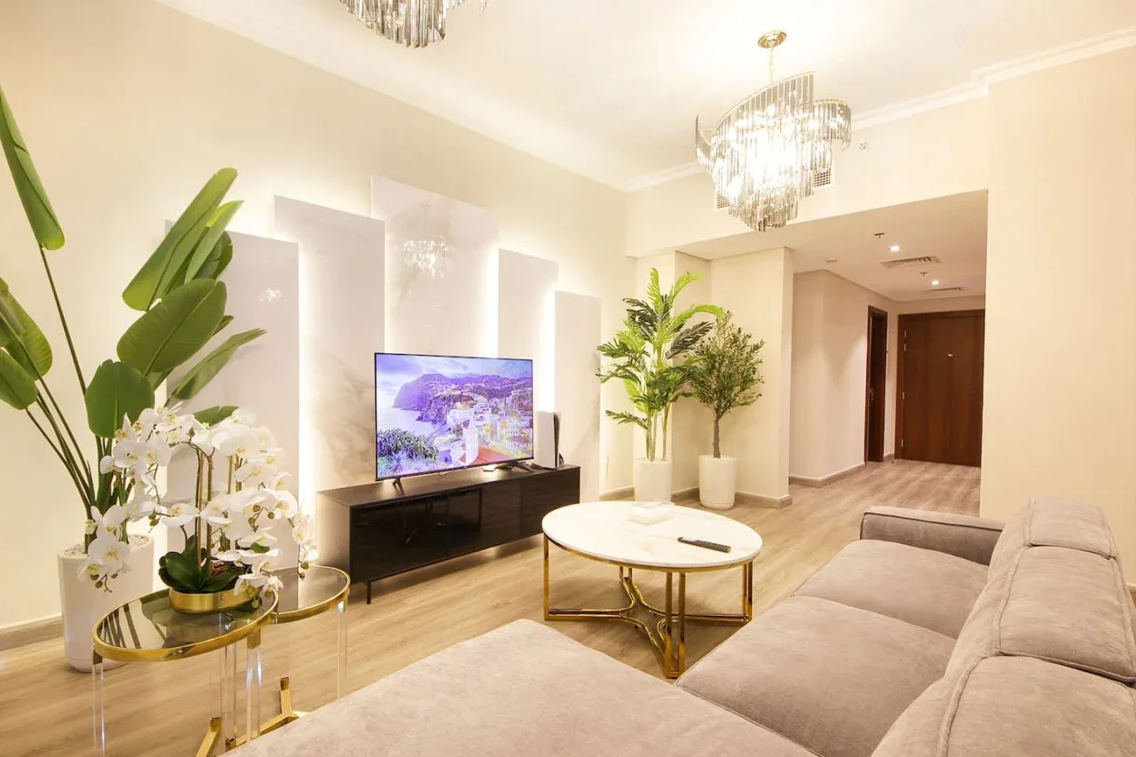A bright living room with a television, coffee table, and seating.