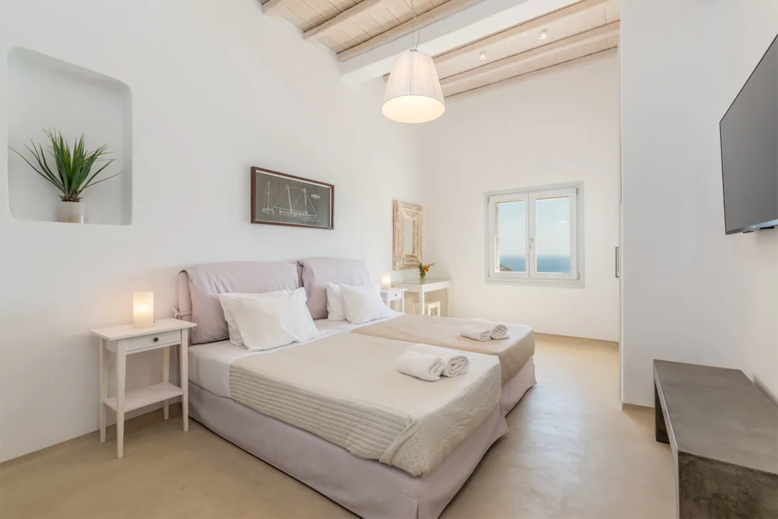 A bright bedroom with a large bed and a window.