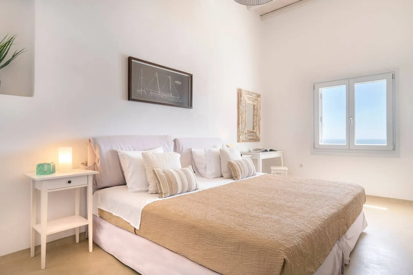 A bright bedroom with a large bed and a window.