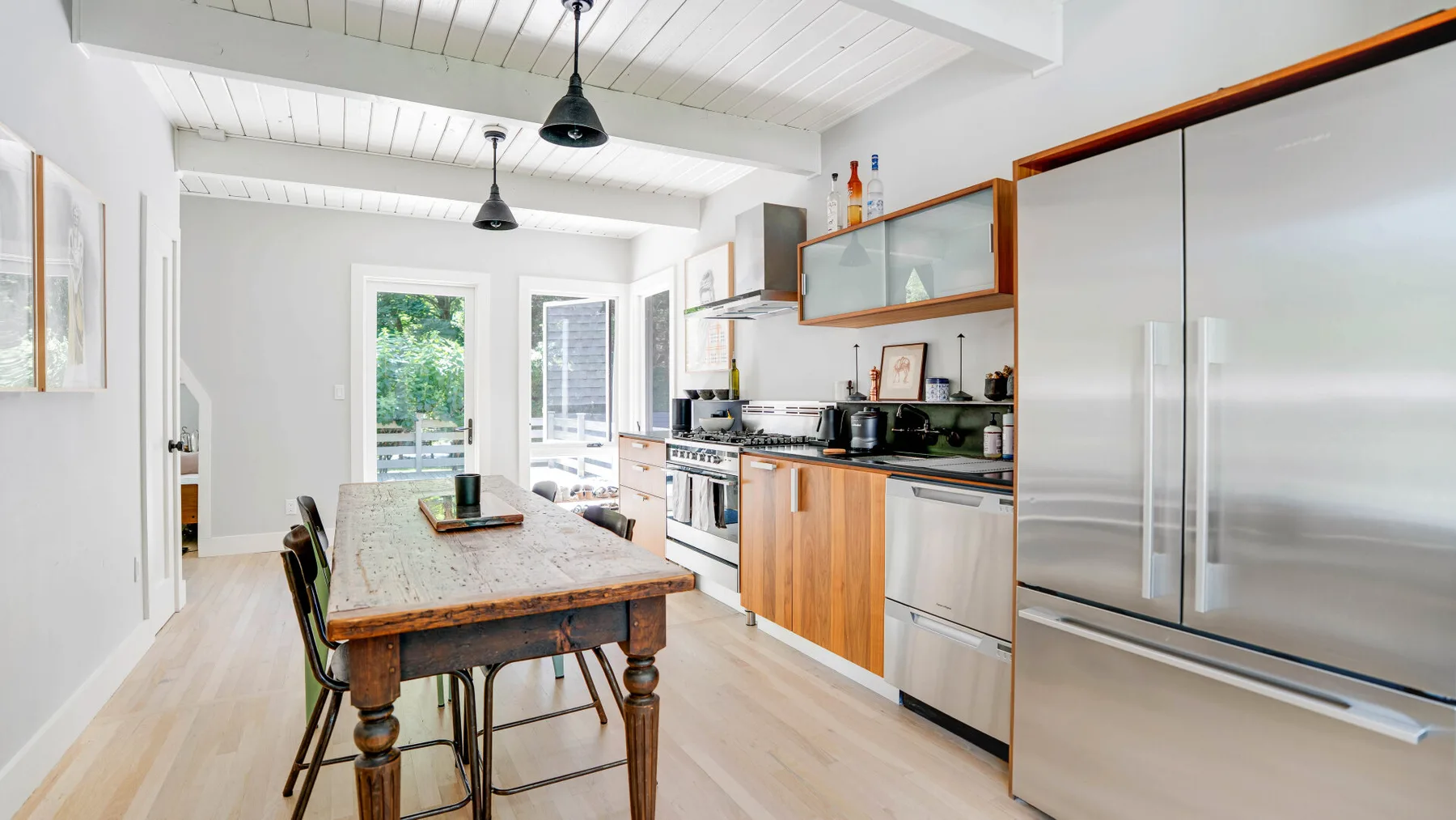 Una cocina luminosa con una isla larga y electrodomésticos de acero inoxidable.