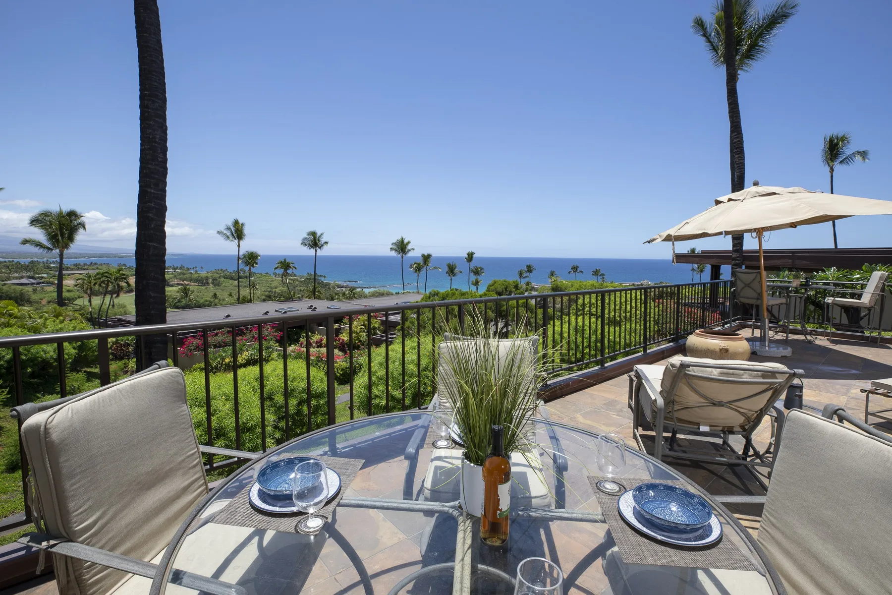 An outdoor dining terrace overlooks landscaped grounds and the ocean.