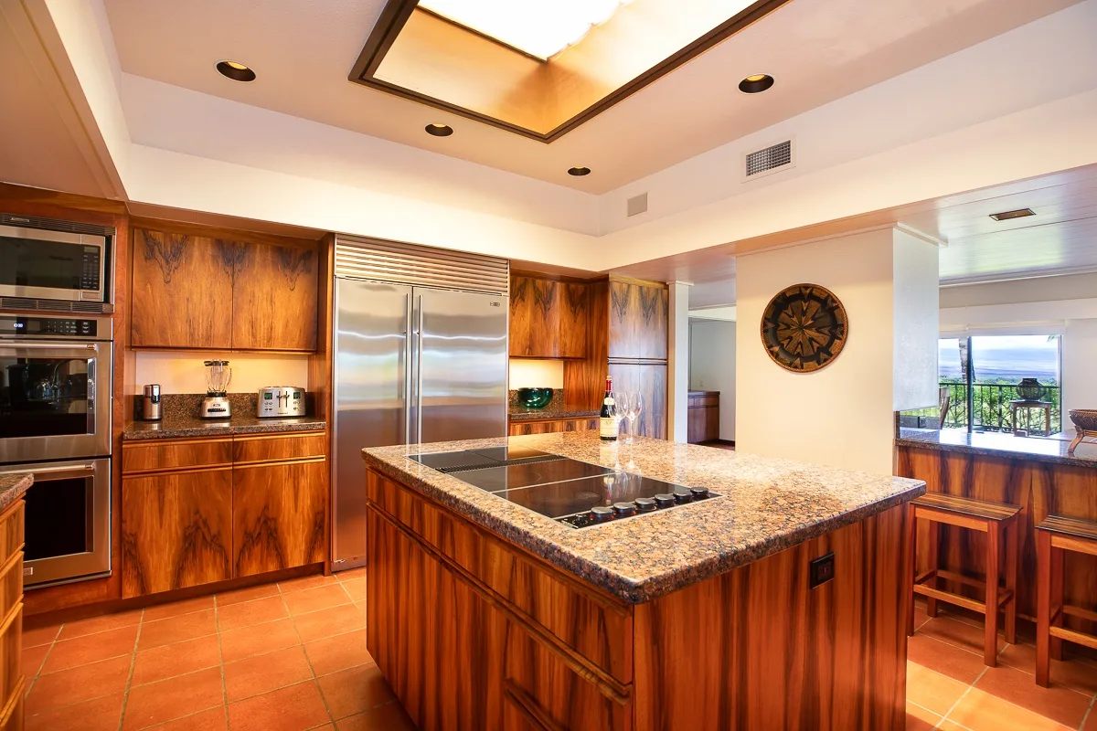 A kitchen with wood cabinetry, stainless steel appliances, and a central island.