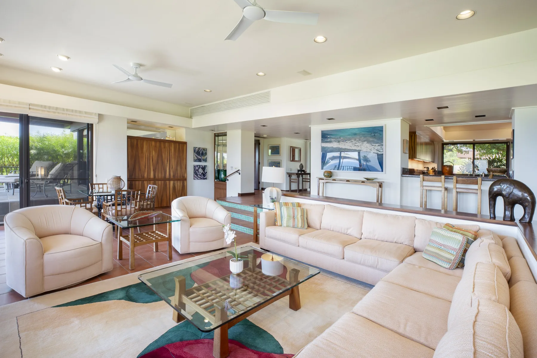 A bright living room with a sectional seating area and glass coffee table.