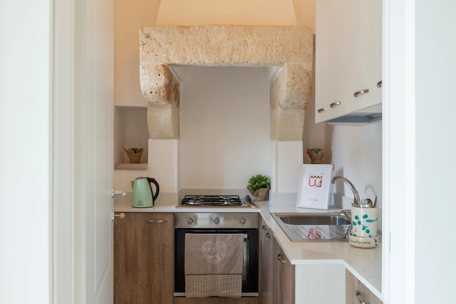 A compact kitchen with a stovetop, oven, and sink.