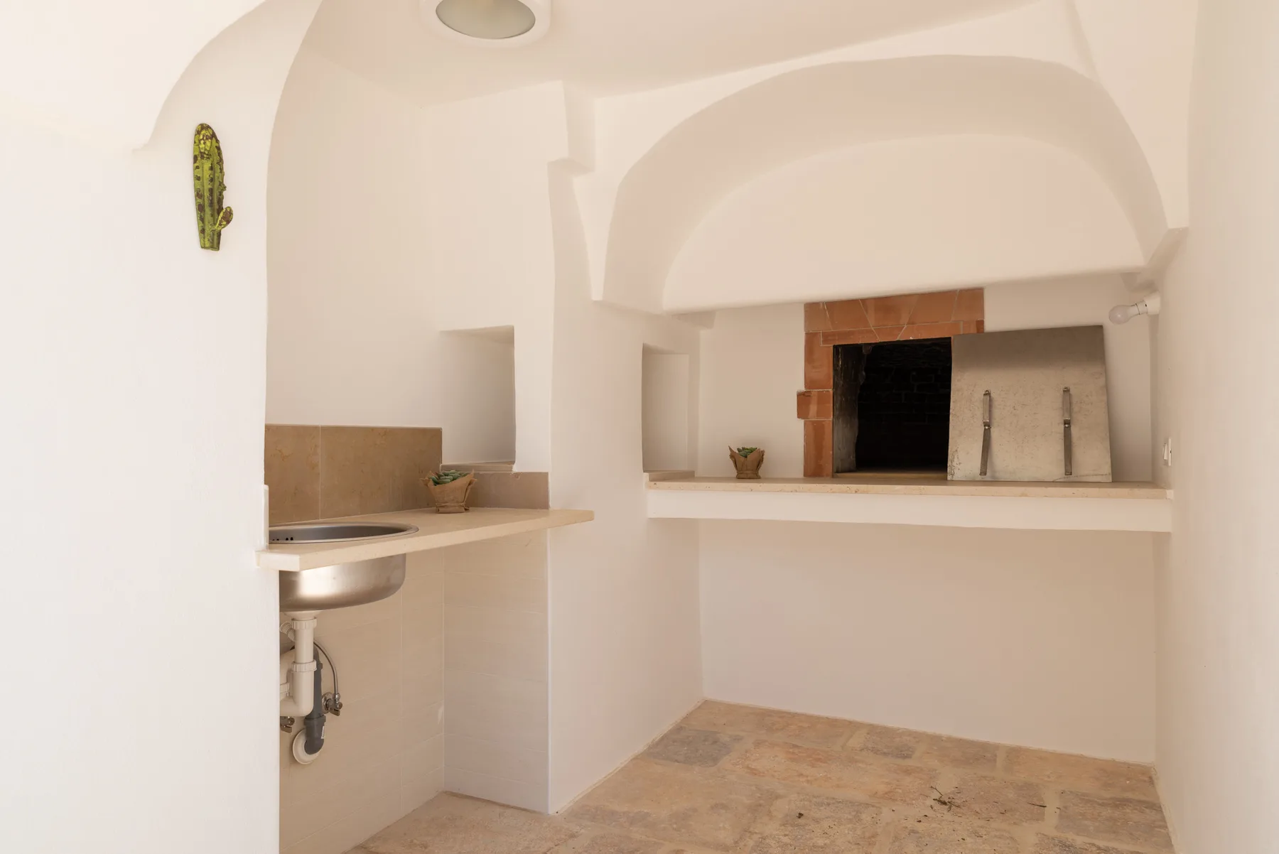 A small kitchen with a counter, sink, and open cooking area.