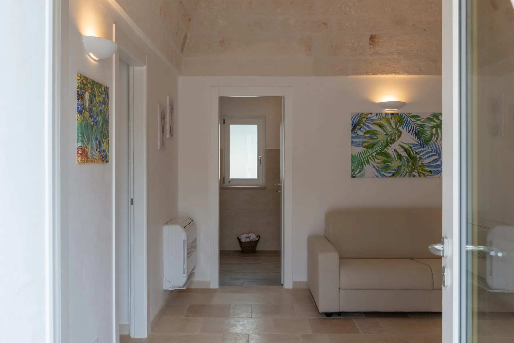 A bright living area with a sofa and colorful botanical wall art.