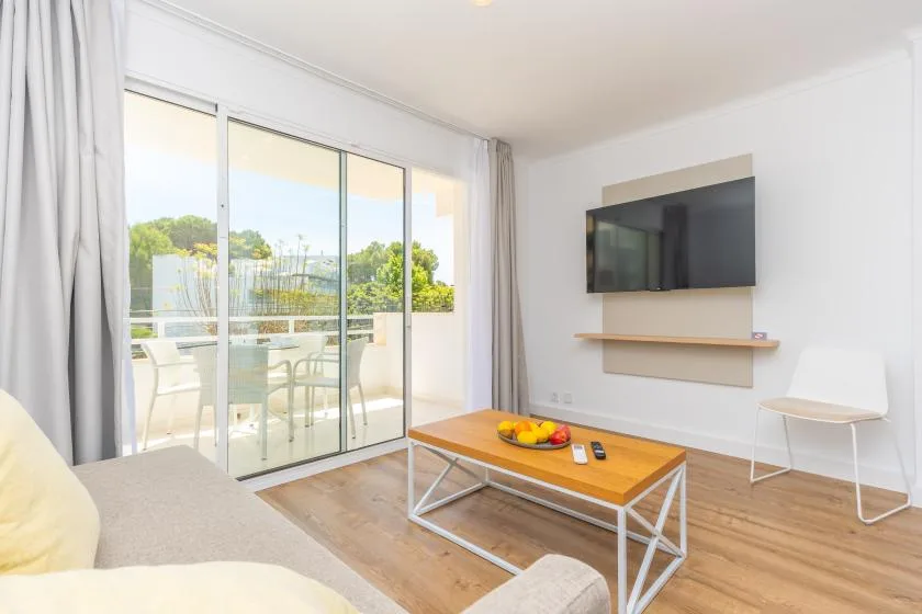 A bright living room with a large sliding glass door opening onto a balcony.