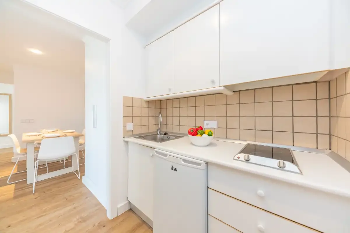 A bright kitchen with a tiled backsplash and dining area.