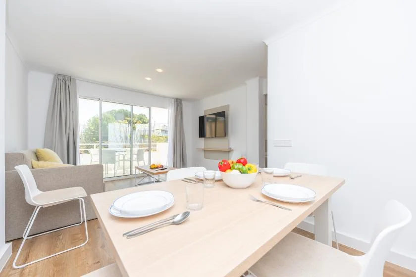 A bright dining area with a set table beside large windows.